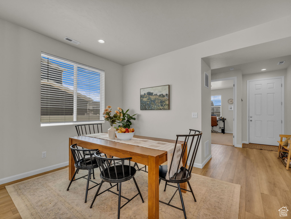Dining area featuring light wood-style flooring, healthy amount of natural light, baseboards, and recessed lighting