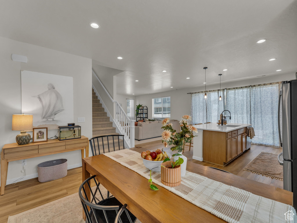 Dining area featuring light wood-style flooring, recessed lighting, and stairway