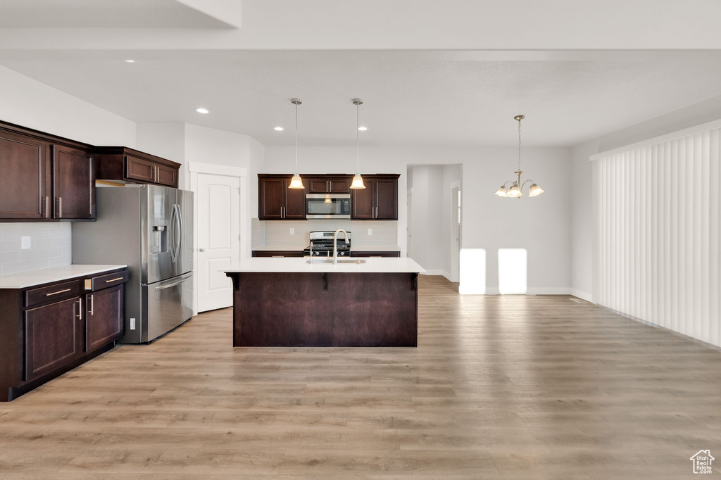 Kitchen with appliances with stainless steel finishes, light countertops, light wood finished floors, and recessed lighting