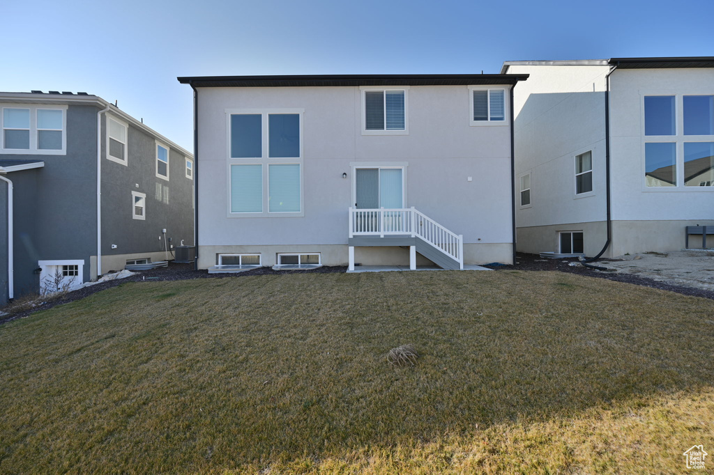 Back of house featuring a yard and stucco siding