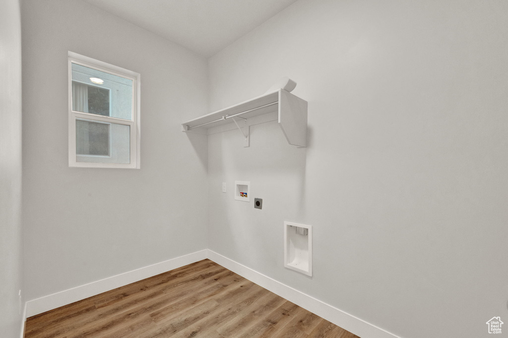 Laundry area featuring washer hookup, hookup for an electric dryer, baseboards, and light wood finished floors