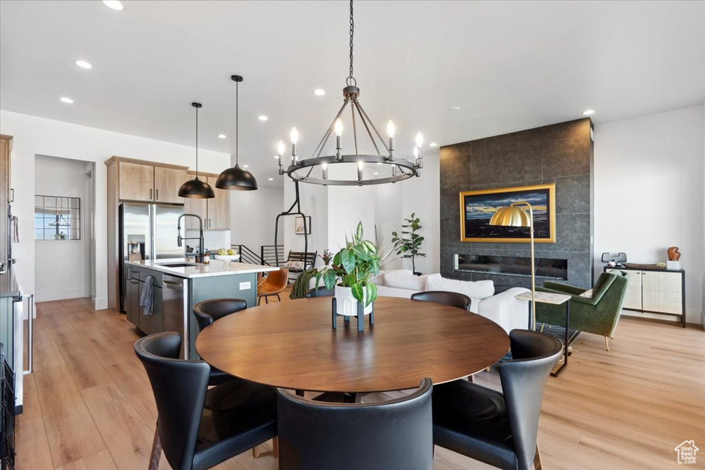 Dining space with radiator heating unit, light wood-style floors, a chandelier, recessed lighting, and baseboards