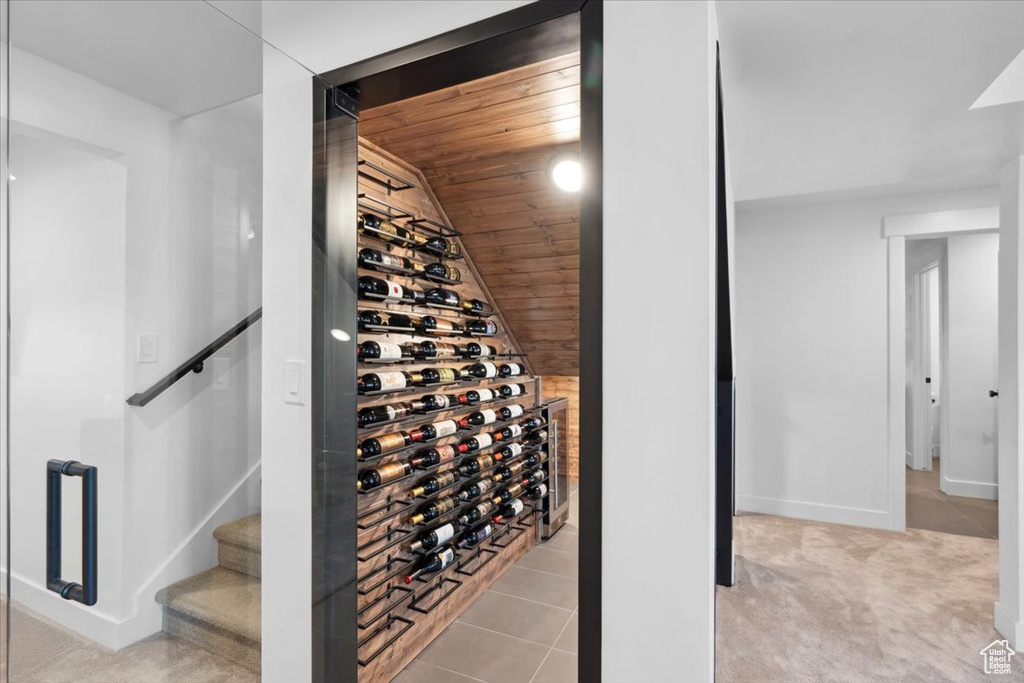 Wine area featuring wooden ceiling, baseboards, lofted ceiling, and carpet floors