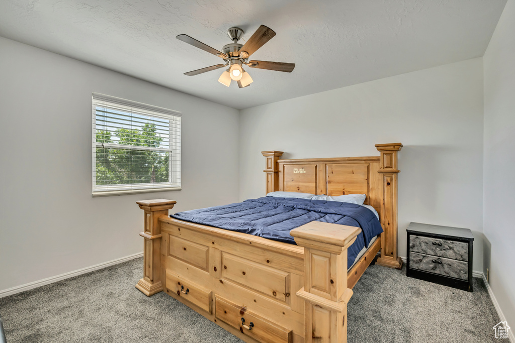 Carpeted bedroom featuring baseboards and ceiling fan