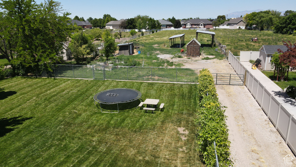 View of yard featuring a trampoline and a residential view