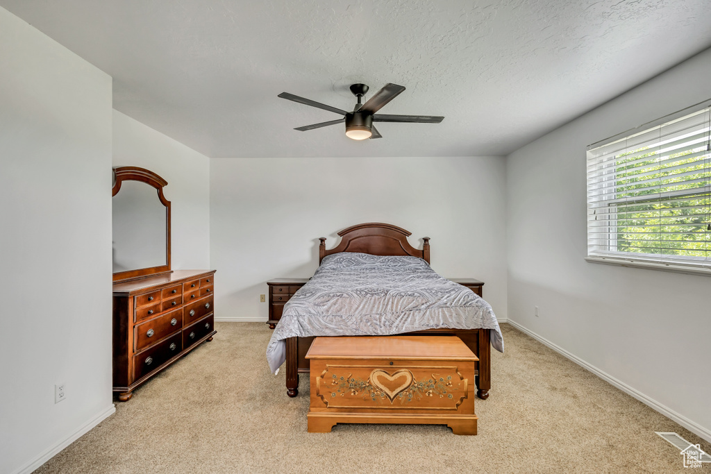 Carpeted bedroom with baseboards, a ceiling fan, and a textured ceiling