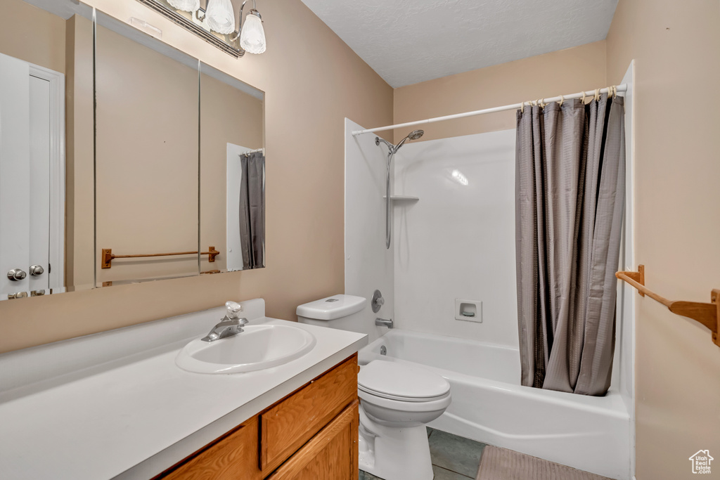 Full bathroom featuring vanity, shower / bath combination with curtain, toilet, and tile patterned flooring