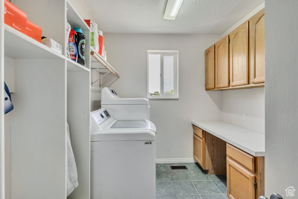 Washroom featuring separate washer and dryer, cabinet space, and baseboards