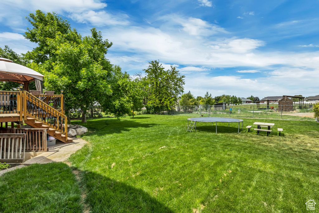 View of yard with a trampoline and a gazebo