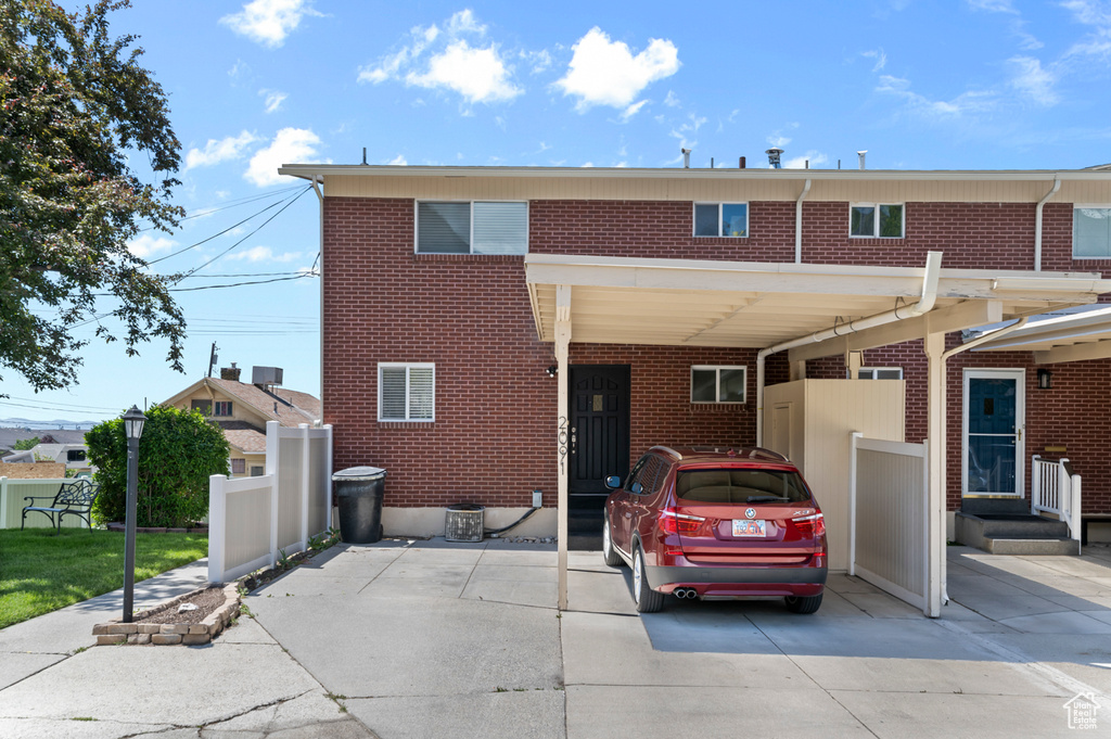Townhome / multi-family property featuring brick siding and a carport