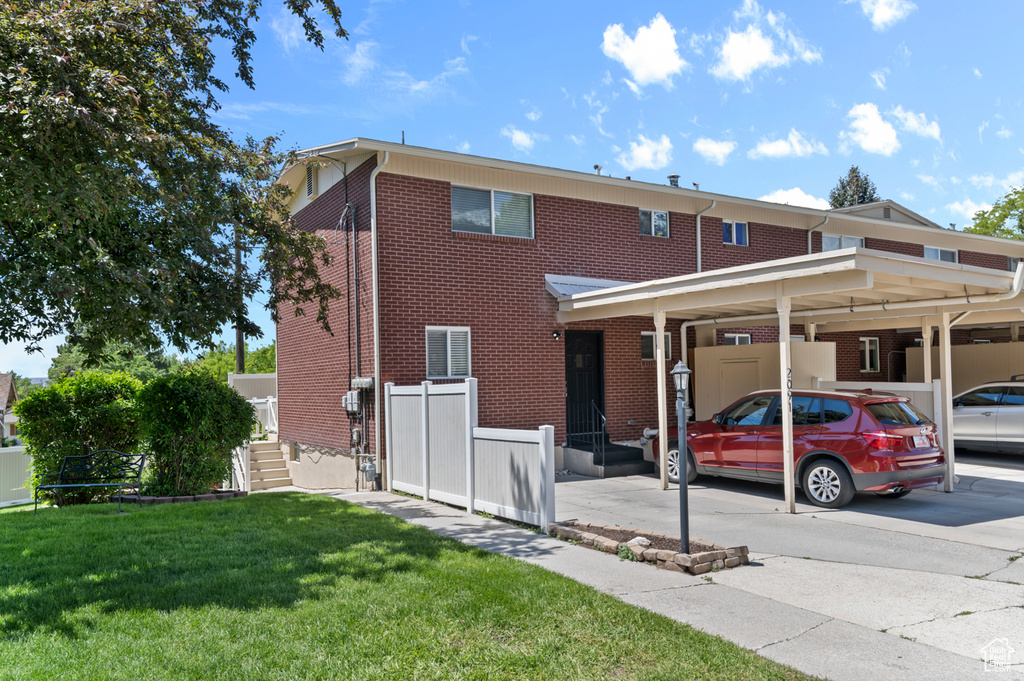 View of front of property featuring brick siding and a carport
