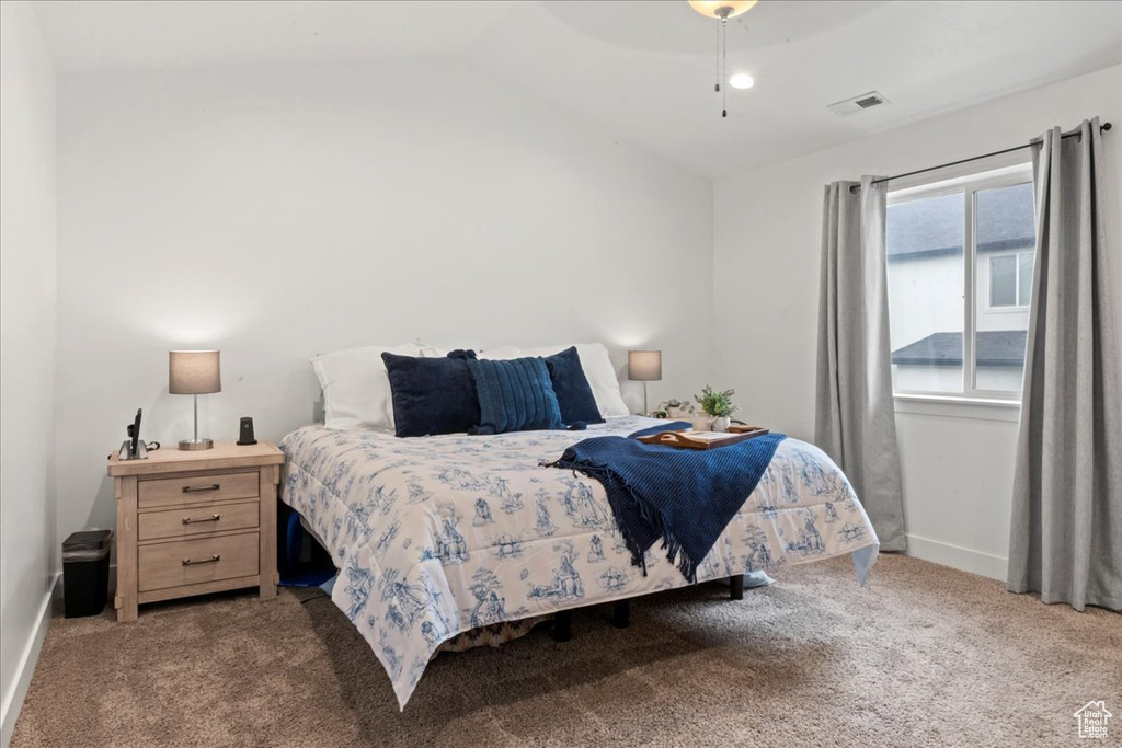 Carpeted bedroom featuring lofted ceiling and baseboards