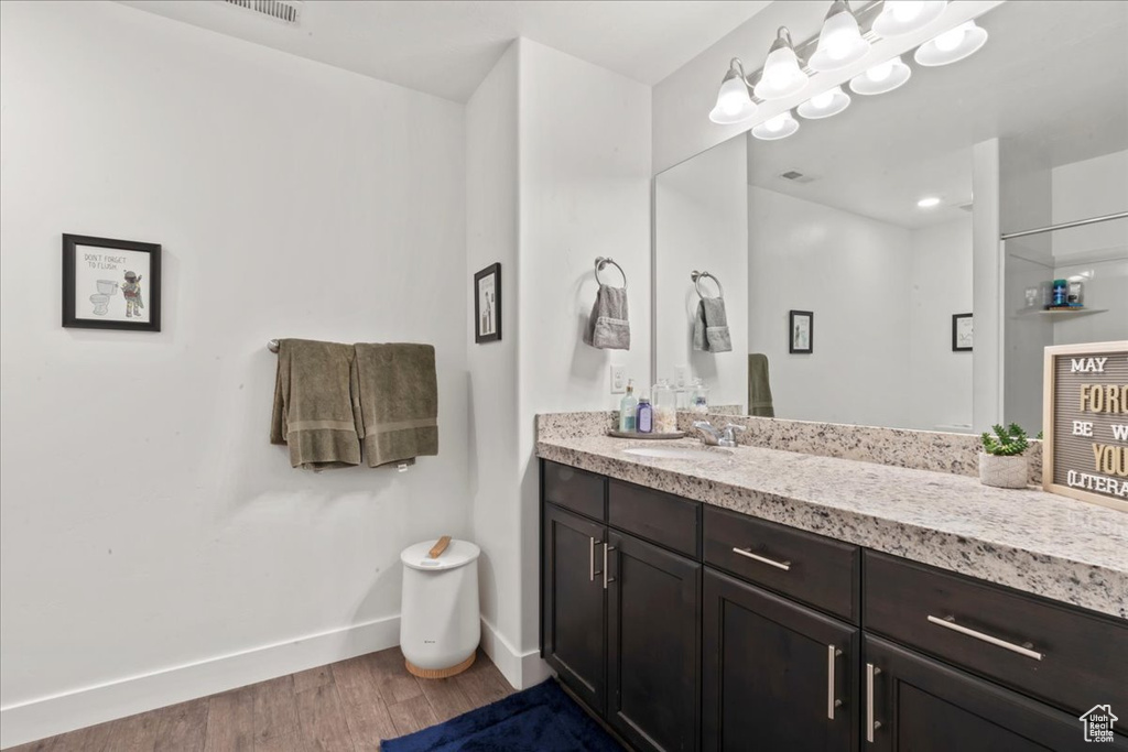 Bathroom featuring vanity, wood finished floors, and baseboards