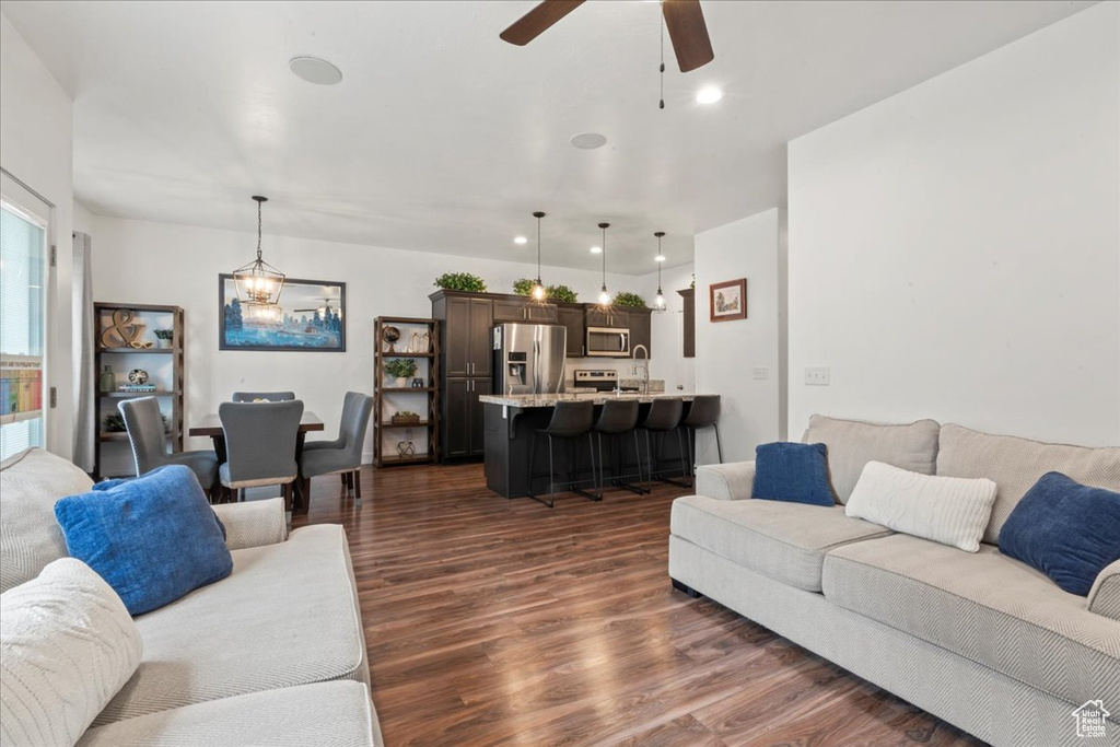 Living room featuring dark wood-style floors, a ceiling fan, and recessed lighting