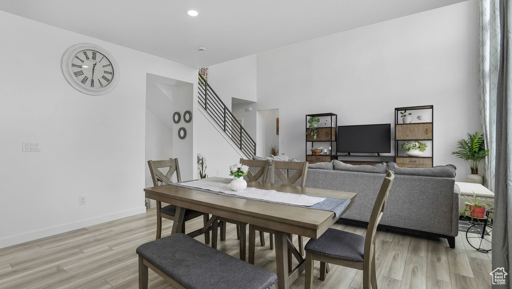 Dining space with light wood-style flooring, stairs, baseboards, and recessed lighting