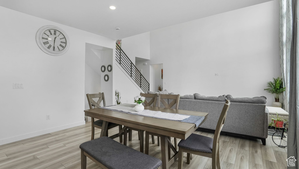 Dining area with light wood-style floors, stairway, baseboards, and recessed lighting