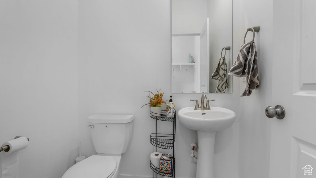 Half bath featuring toilet and a sink