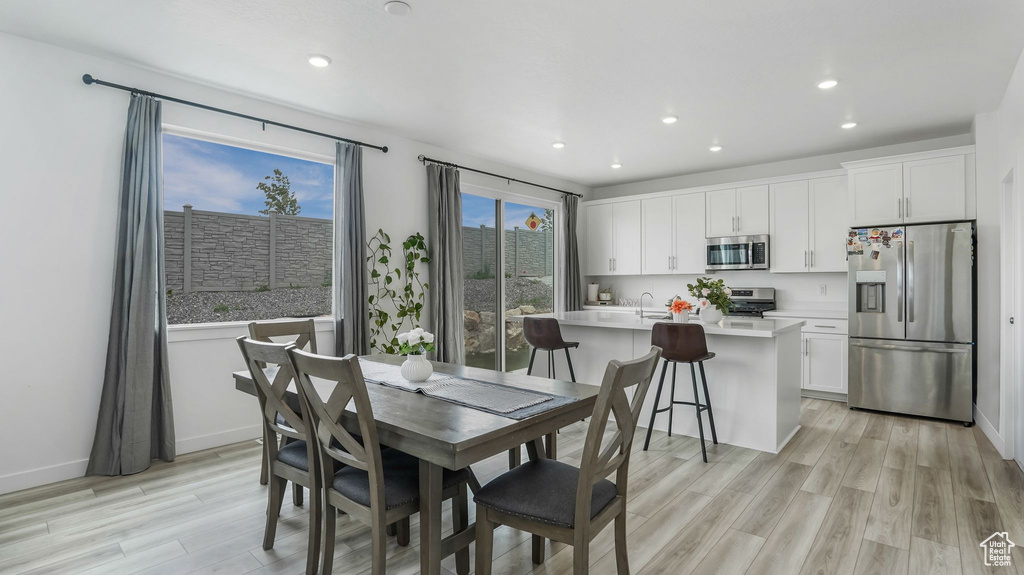 Dining area featuring light wood finished floors, recessed lighting, and baseboards