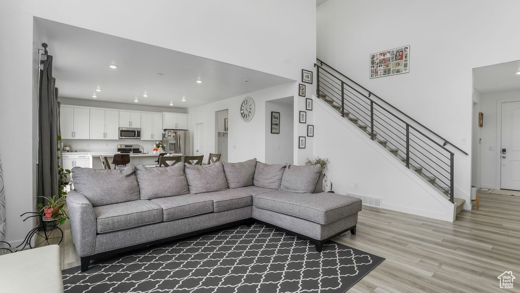 Living area featuring recessed lighting, light wood-style floors, and stairs