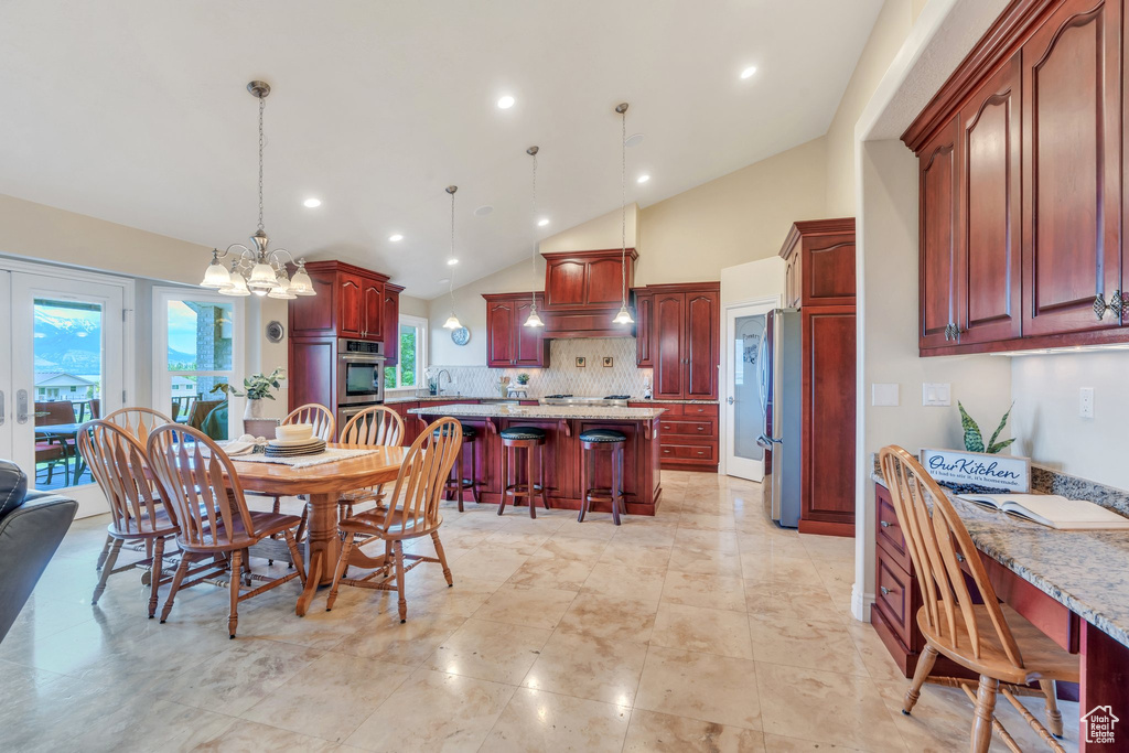 Dining room with vaulted ceiling, a chandelier, recessed lighting, and plenty of natural light