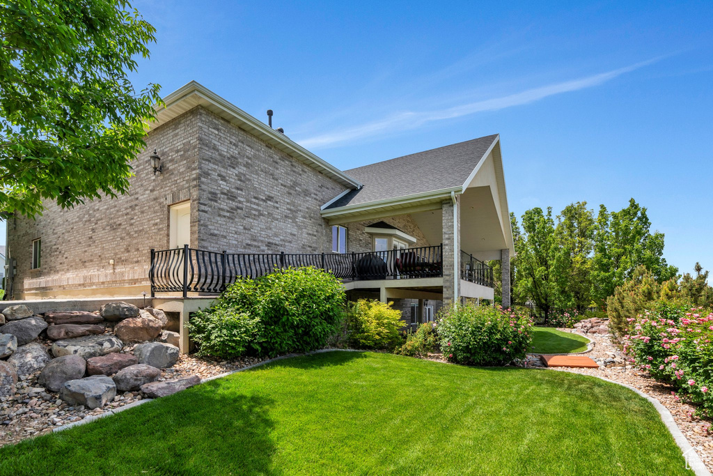 Rear view of house featuring brick siding and a yard