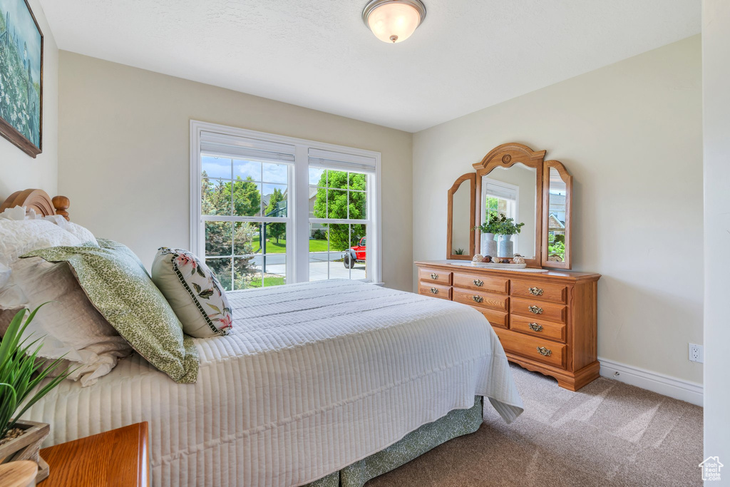 Bedroom featuring light colored carpet and baseboards