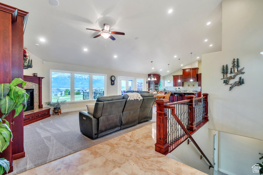 Living area featuring vaulted ceiling, a premium fireplace, recessed lighting, and a ceiling fan