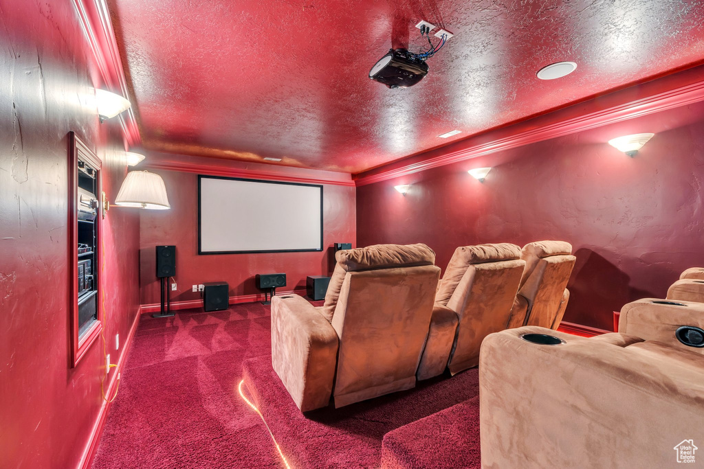 Home theater with carpet floors, a textured ceiling, crown molding, and baseboards