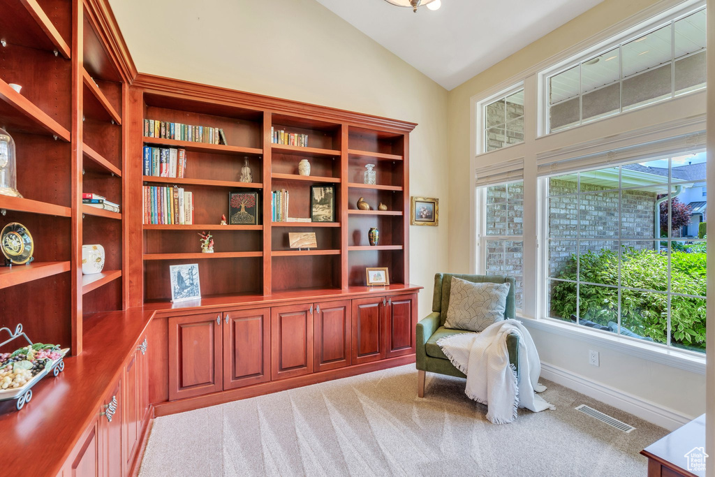 Sitting room featuring vaulted ceiling, light colored carpet, and baseboards