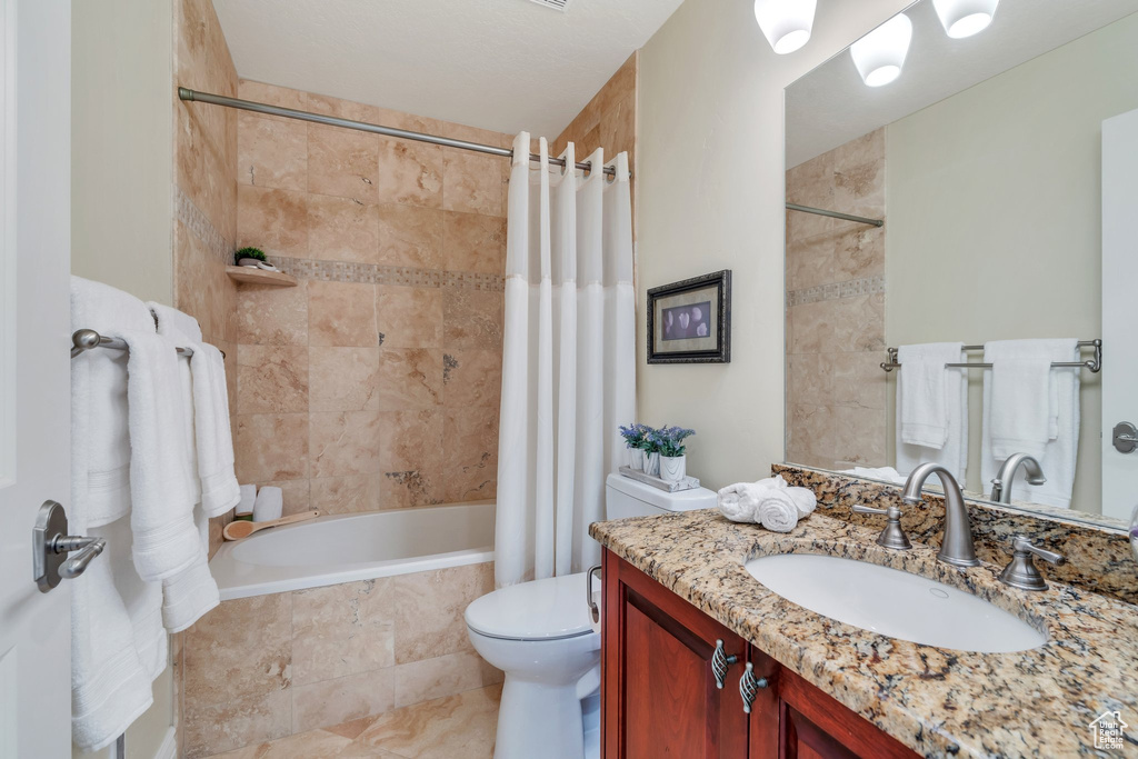 Full bath featuring vanity, toilet, and tiled shower / bath combo