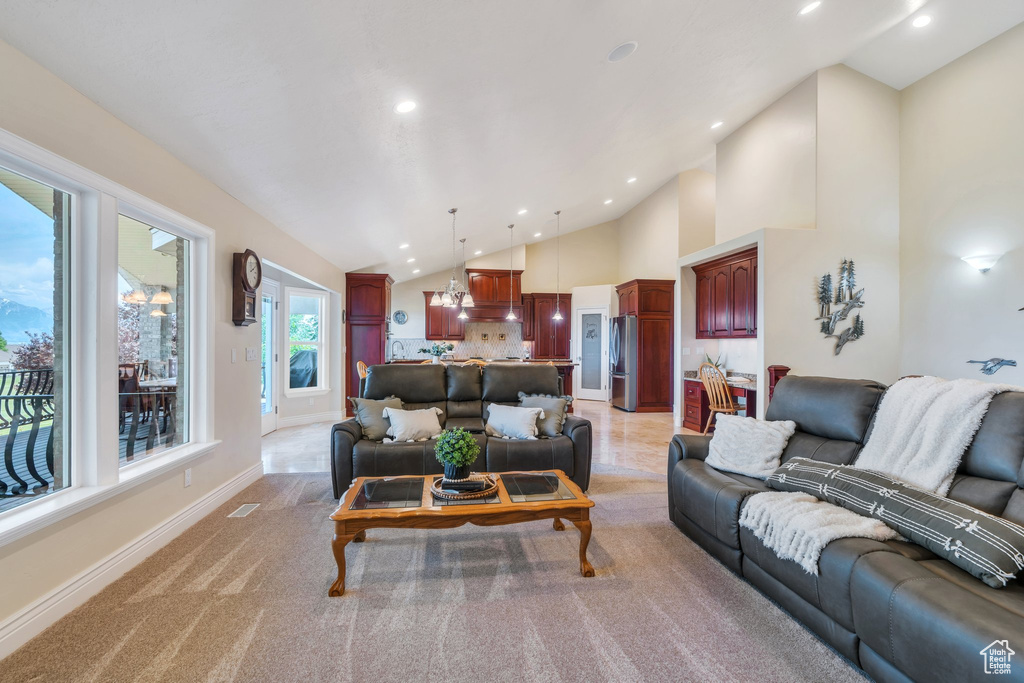 Living area with recessed lighting, baseboards, light colored carpet, and high vaulted ceiling