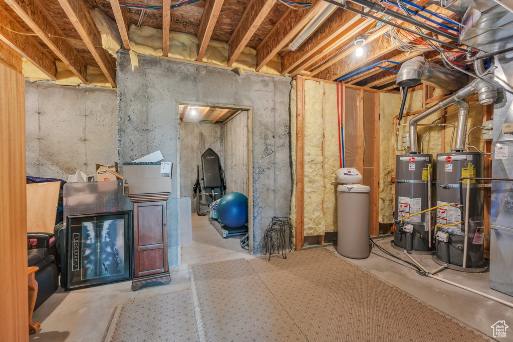 Unfinished basement featuring strapped water heater and a water softener
