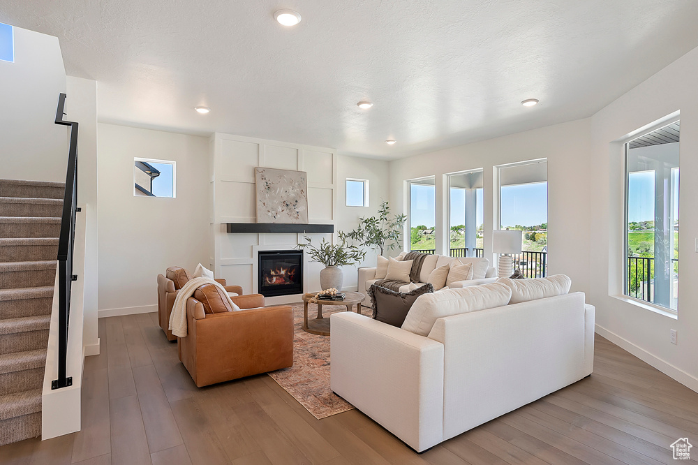 Living room featuring stairs, healthy amount of natural light, light wood-type flooring, and recessed lighting