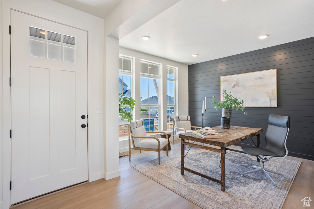Office featuring light wood finished floors, wood walls, recessed lighting, and baseboards