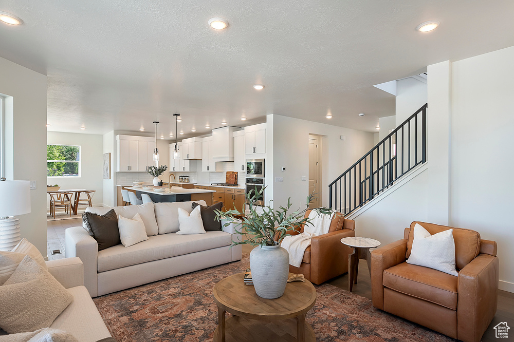 Living area featuring recessed lighting, stairs, and baseboards