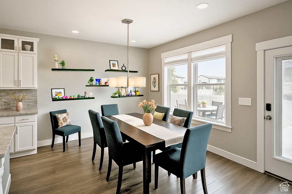 Dining area with dark wood-type flooring, recessed lighting, and baseboards