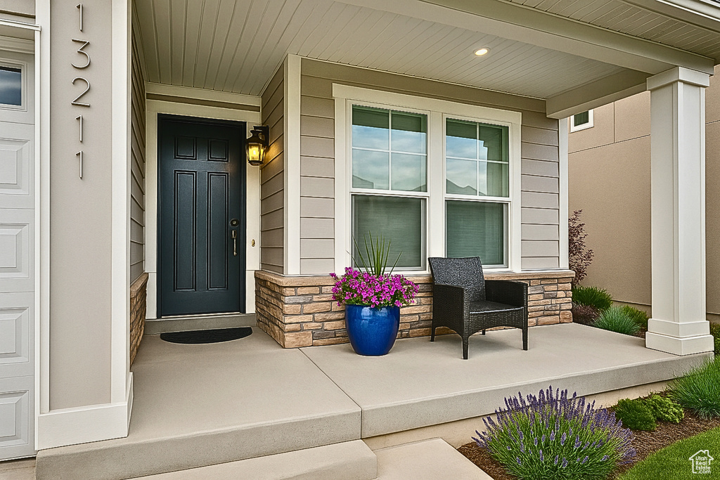 Entrance to property featuring covered porch and stone siding