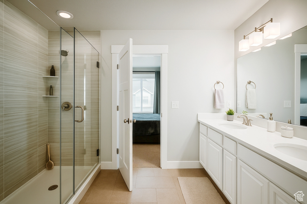 Ensuite bathroom with double vanity, tile patterned floors, a shower stall, baseboards, and recessed lighting