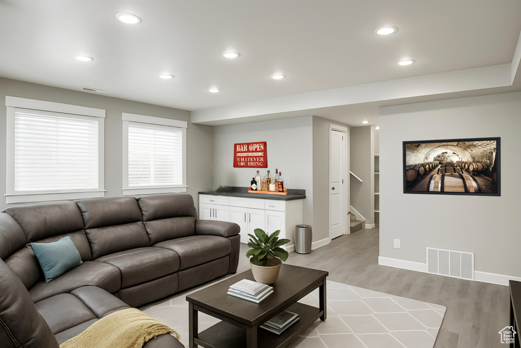 Living area featuring a dry bar, stairway, light wood finished floors, recessed lighting, and baseboards
