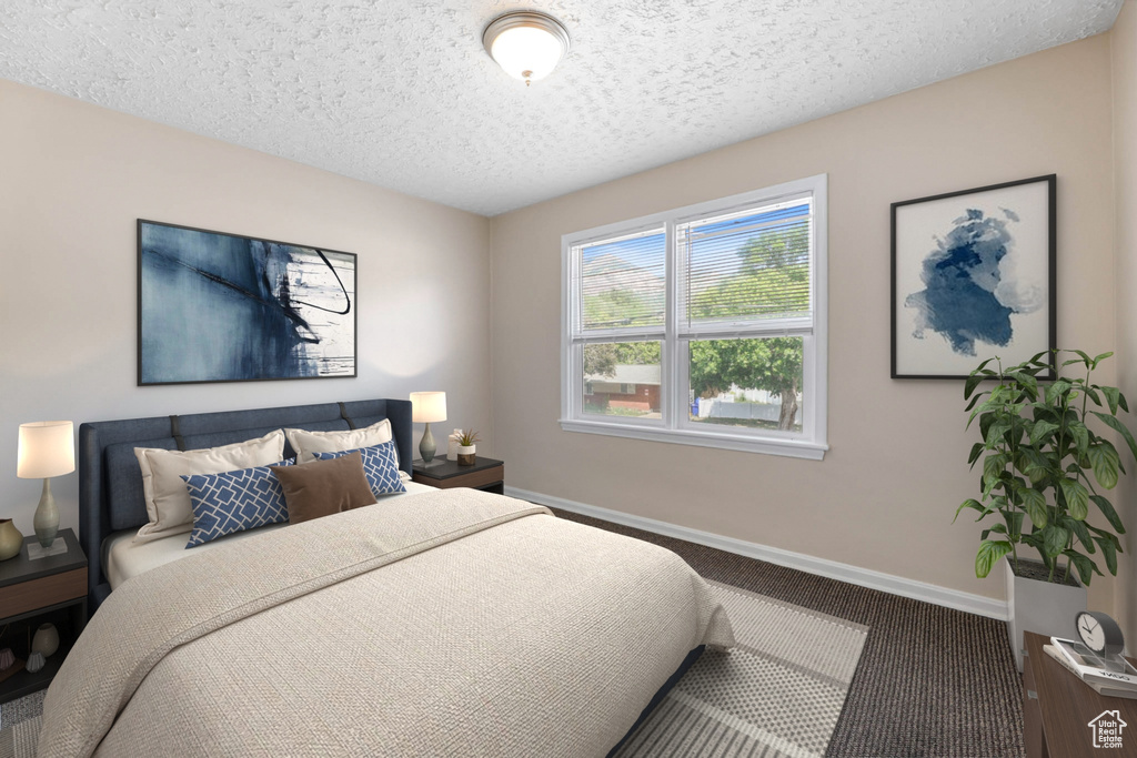Carpeted bedroom with baseboards and a textured ceiling