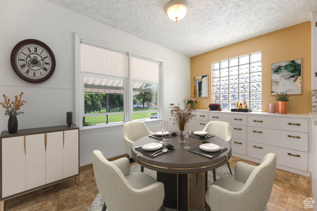 Dining space featuring stone finish flooring, healthy amount of natural light, and a textured ceiling