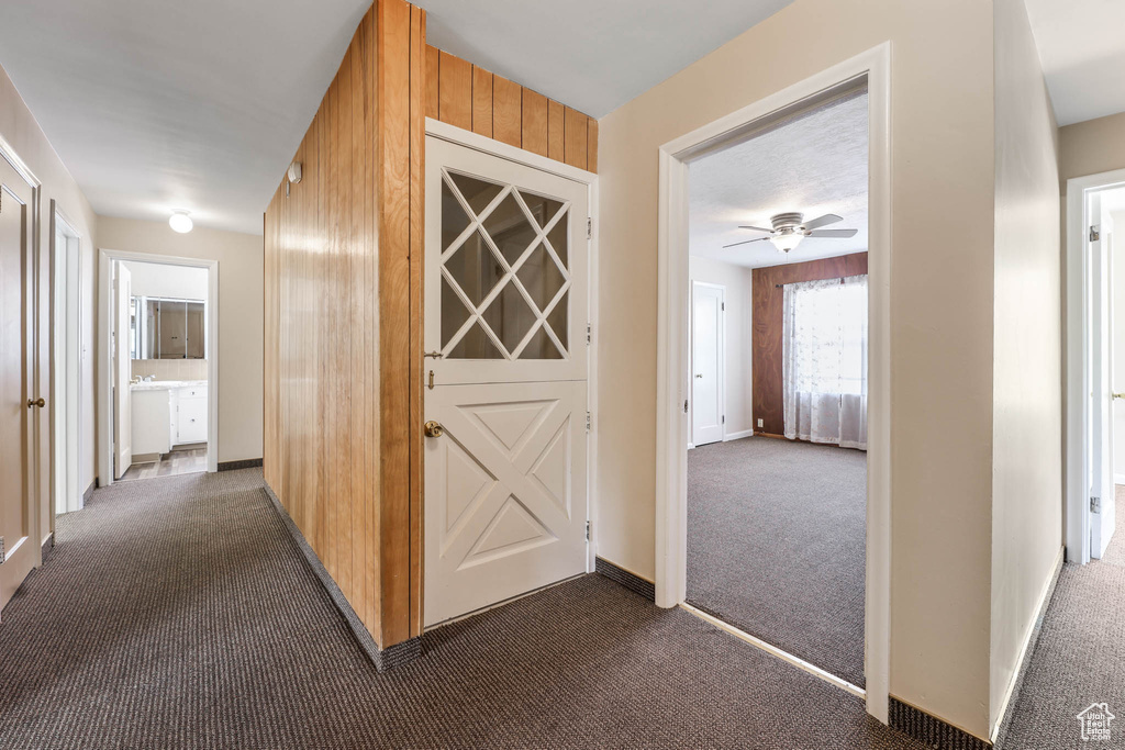Hall with dark carpet and baseboards