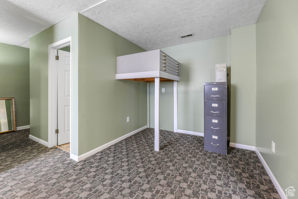 Bonus room featuring baseboards, a textured ceiling, and tile patterned floors