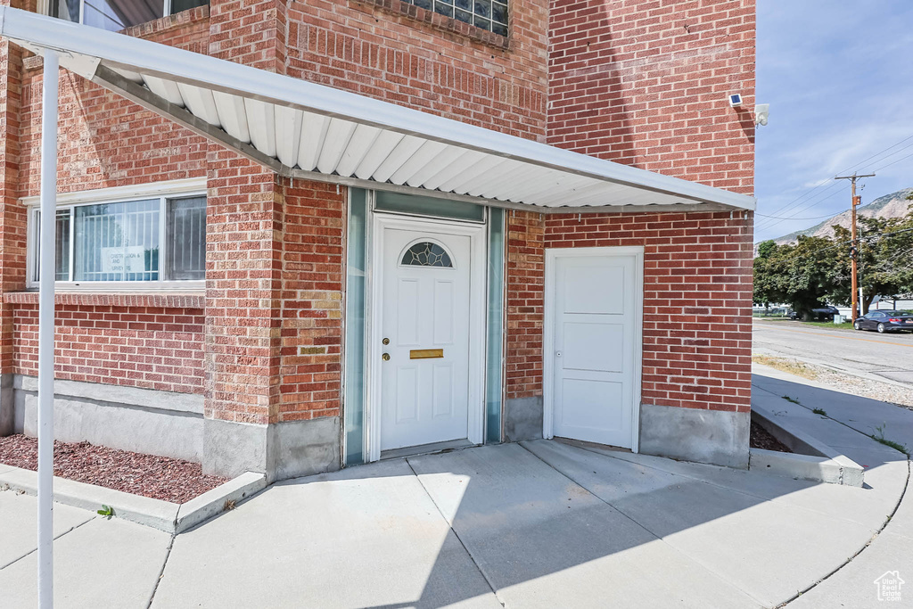 Property entrance featuring brick siding