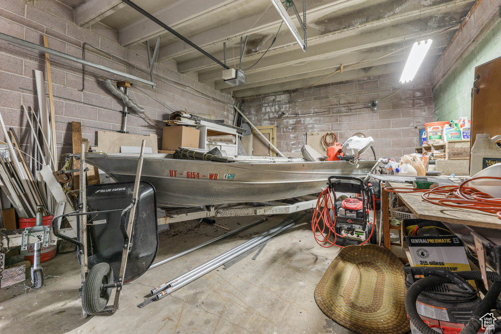 Garage featuring a garage door opener and concrete block wall