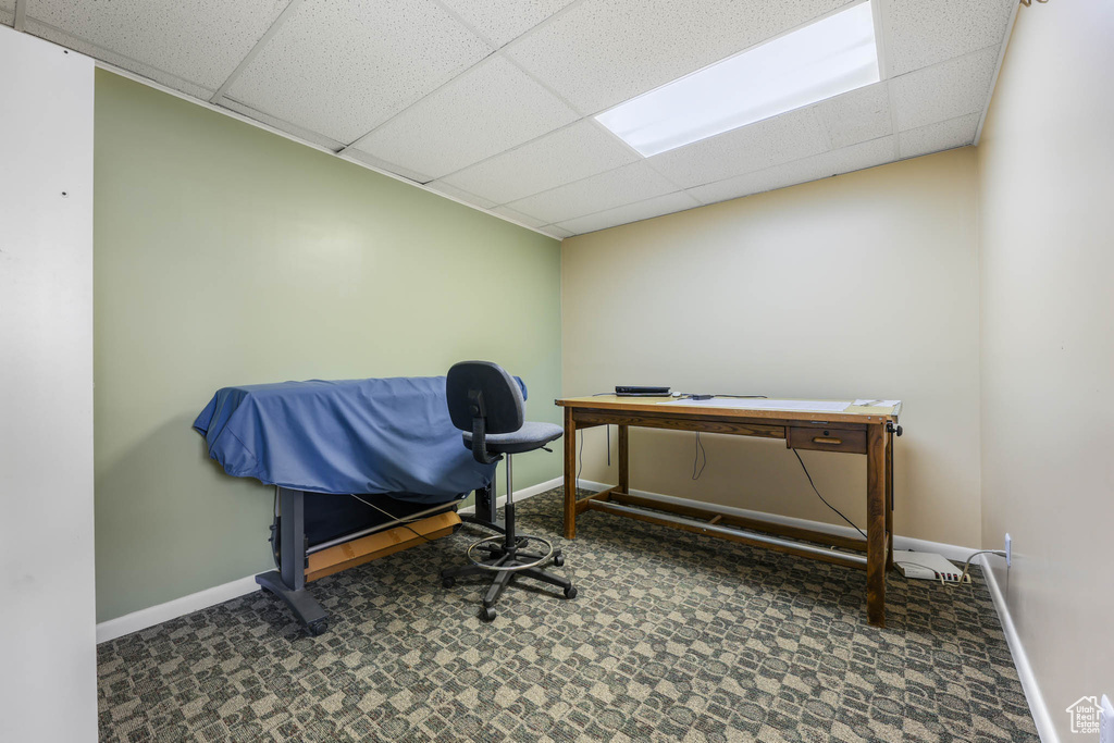 Miscellaneous room featuring a drop ceiling, baseboards, carpet floors, and a desk