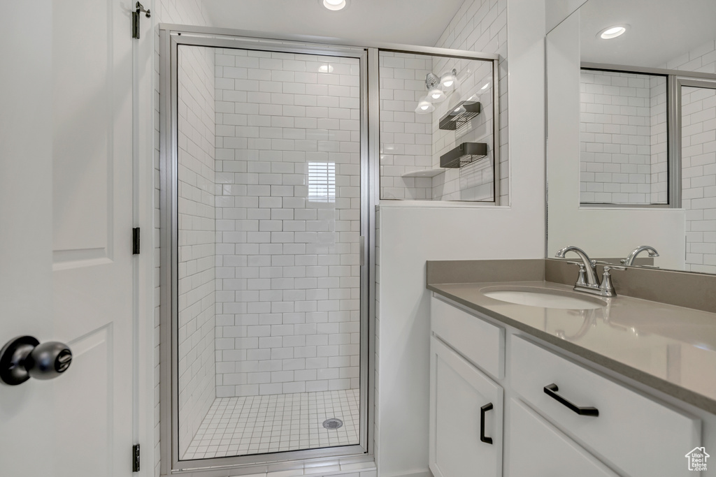 Bathroom featuring a stall shower, vanity, and recessed lighting