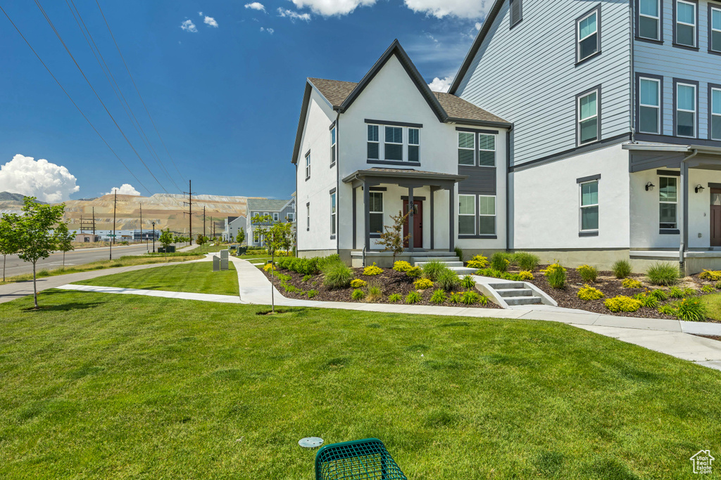 View of front of house with stucco siding and a front yard