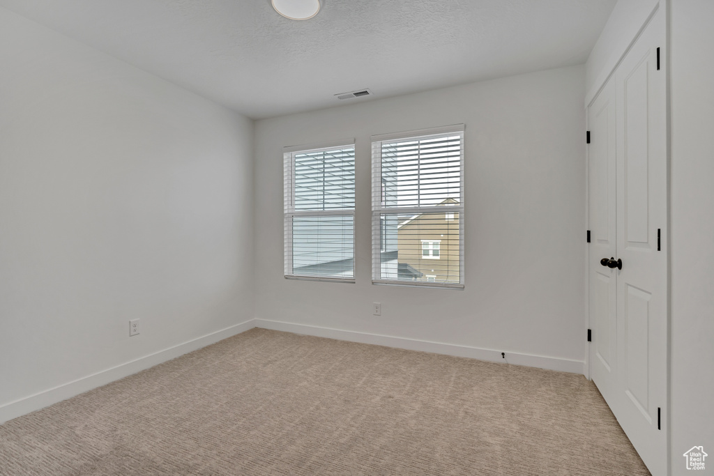 Unfurnished room with light carpet and baseboards