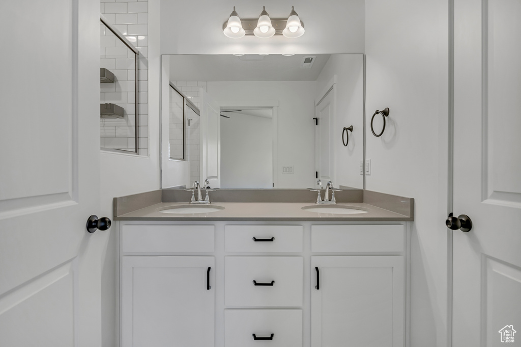 Full bathroom with double vanity and a tile shower